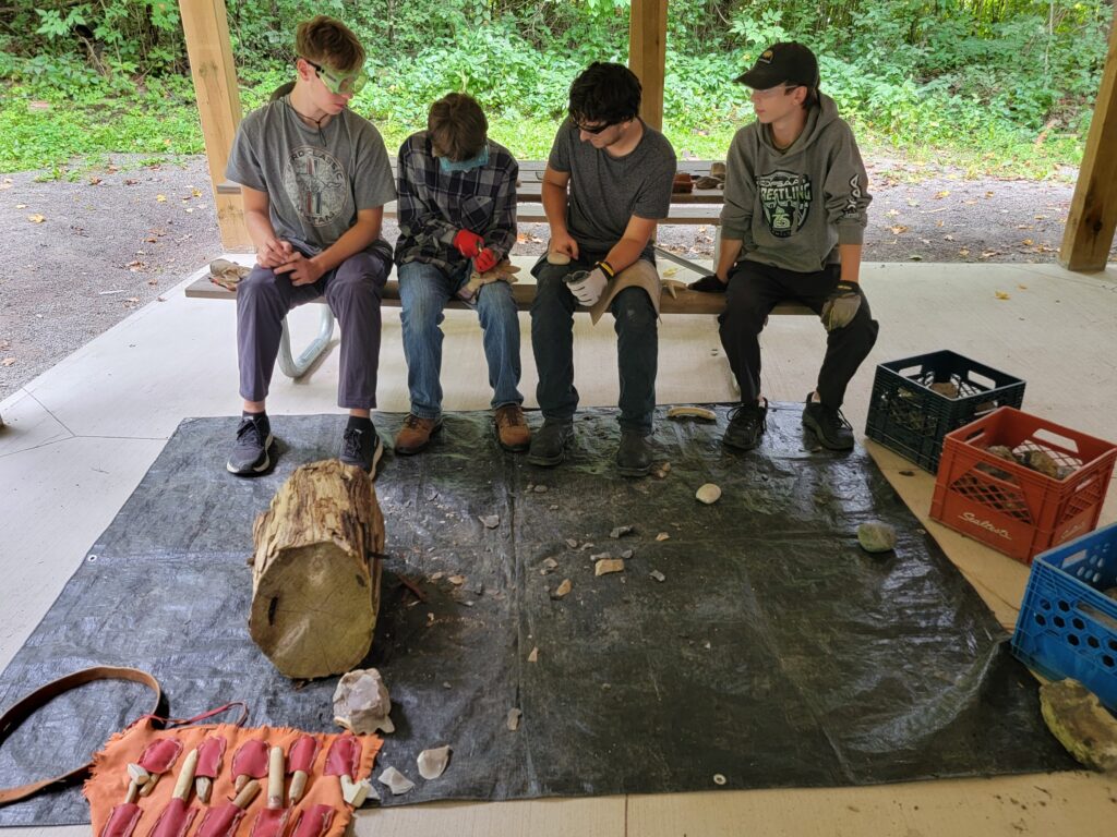 Students practicing their flintknapping skills with onondaga chert, hammerstones and pressure flakers