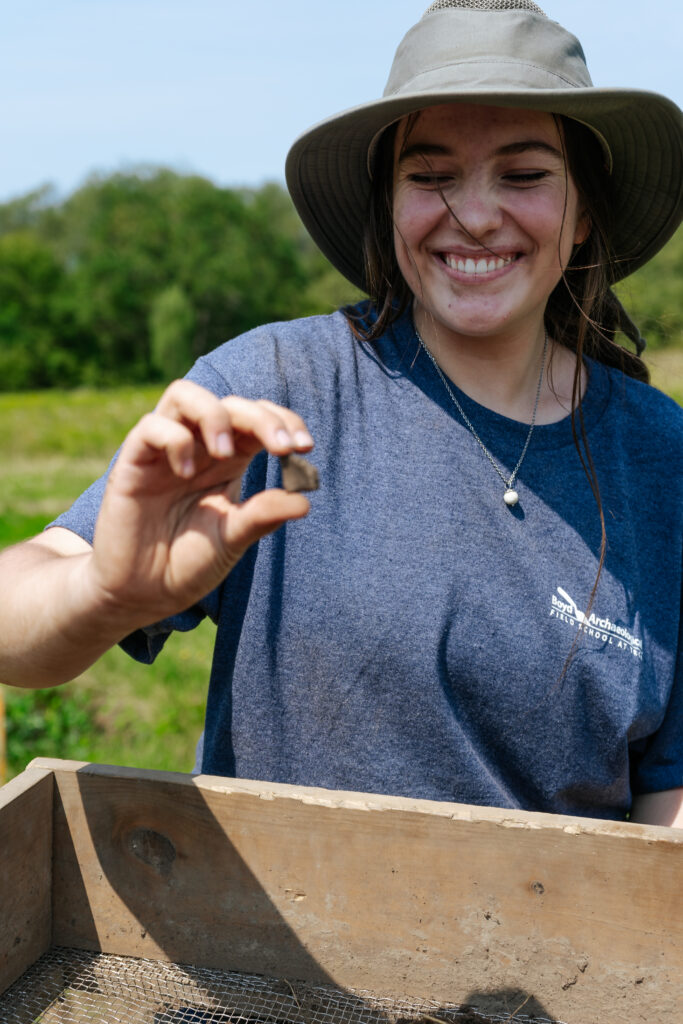 Sebastien Scholarship recipient showing a fragment of ceramic she found during excavations at the Sebastien site